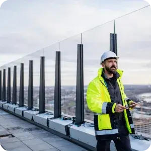A property inspector uses a tablet to complete a digital inspection report on a building rooftop, streamlining the site audit process for faster, more accurate results.