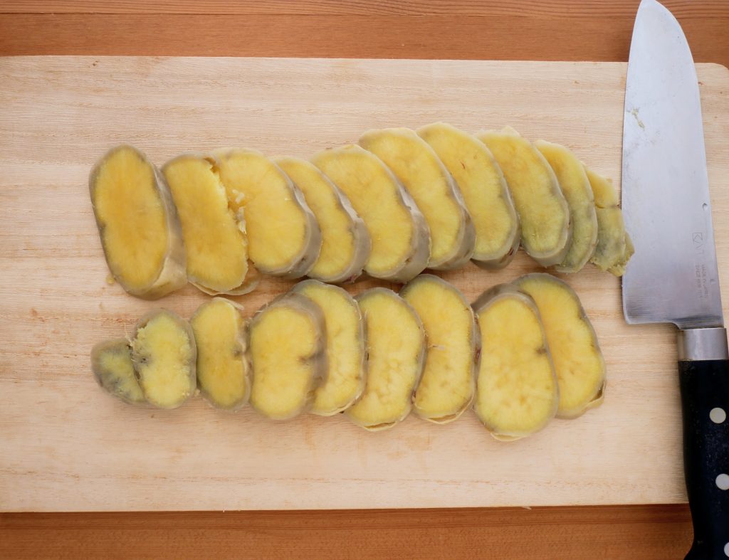 蒸したさつまいもをスライスする様子