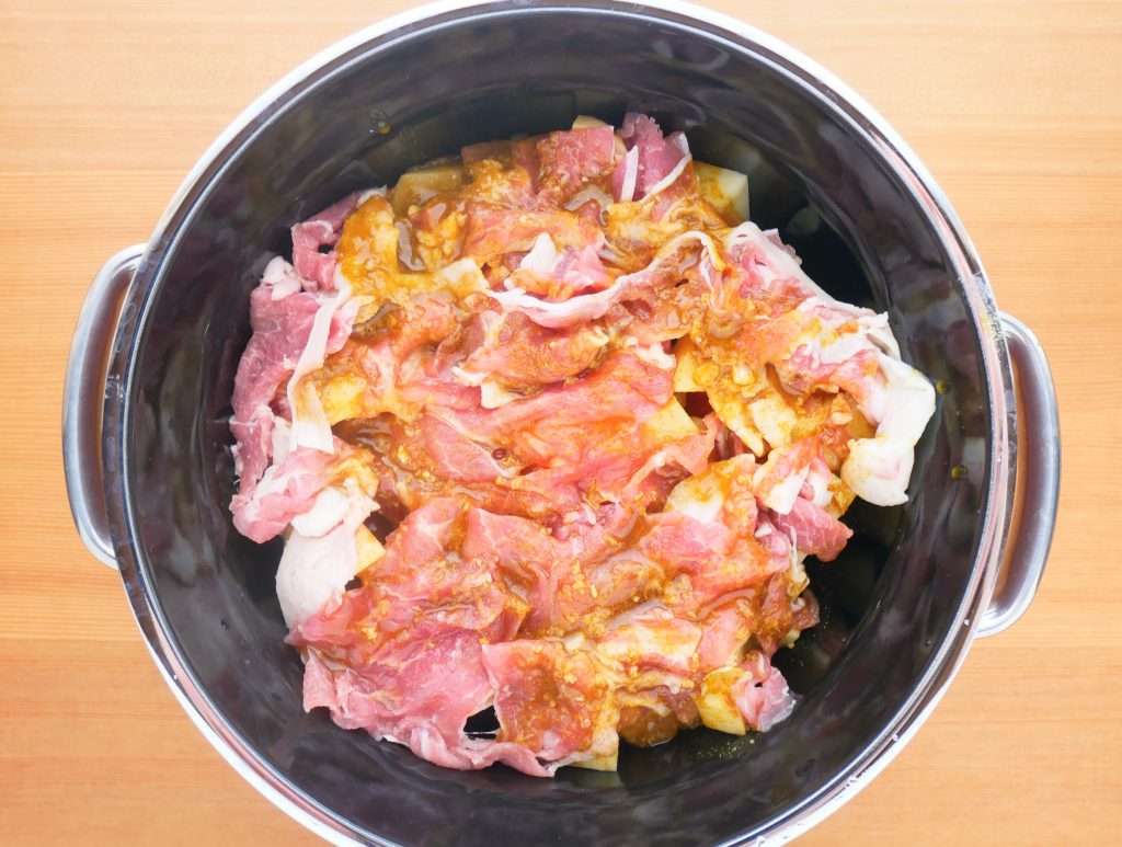 ライスポットにカレー肉じゃがの材料を入れる様子