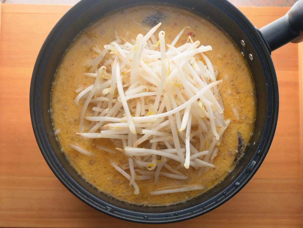 担々スープにもやしを加える様子