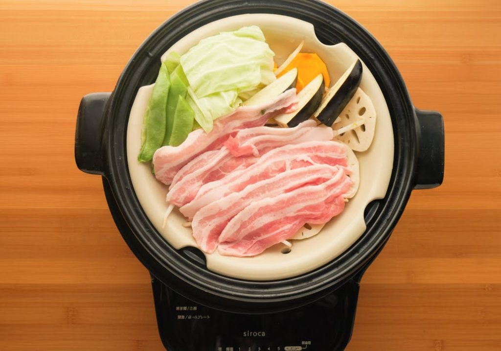 すのこをセットした土鍋に、具材をのせる様子