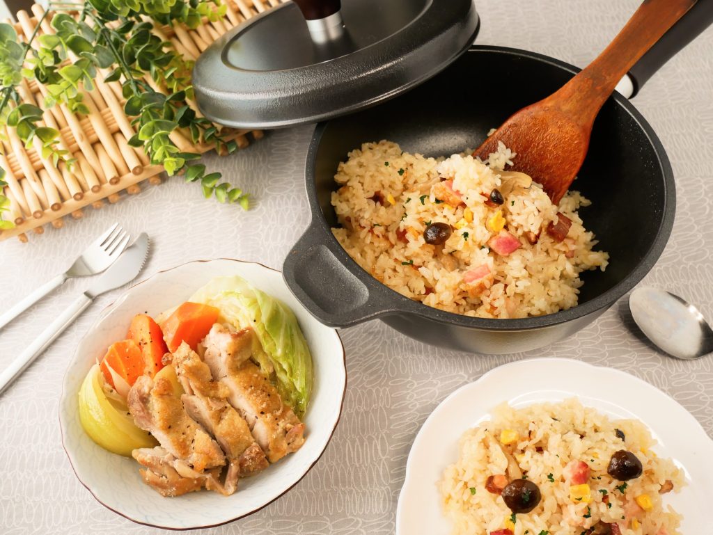 味わい鍋に入ったベーコンときのこのガリバタ炊き込みごはん、皿に盛られた鶏肉と野菜の蒸し煮