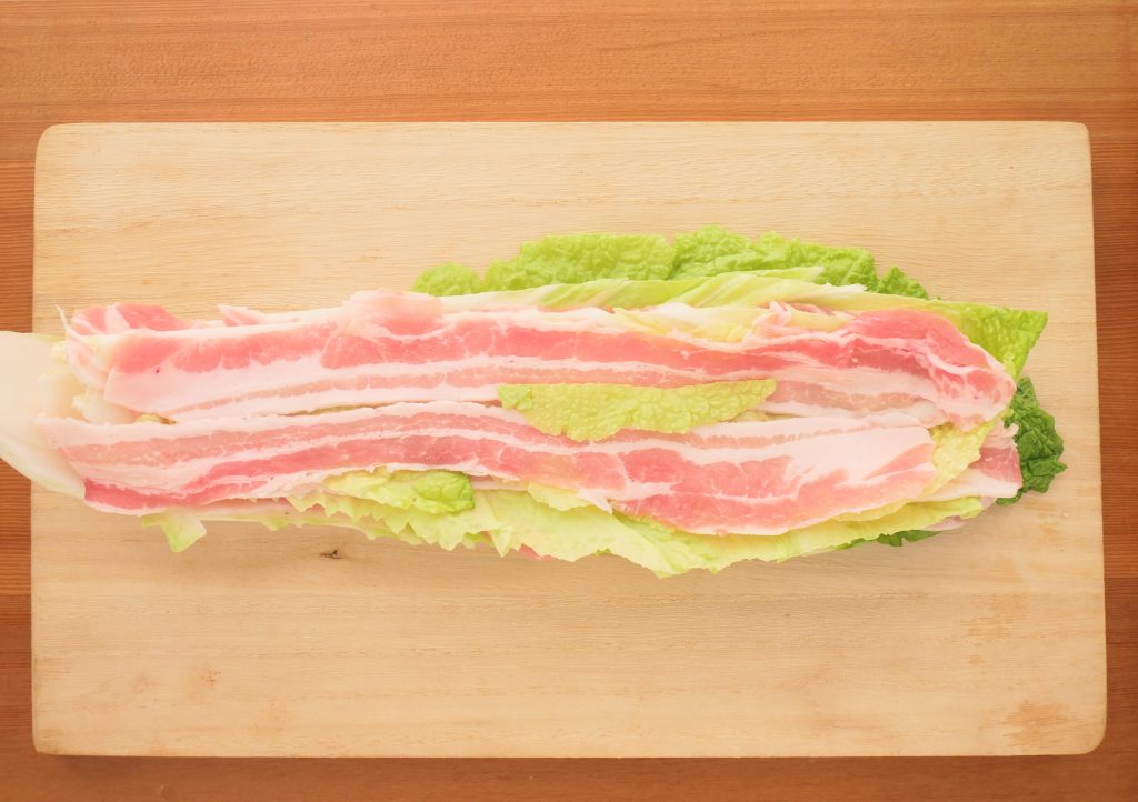 白菜と豚バラ肉を重ねる様子