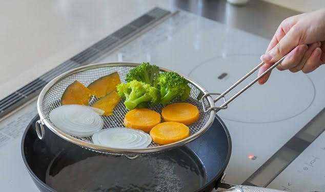 野菜をのせた盆ざるを引き上げる様子