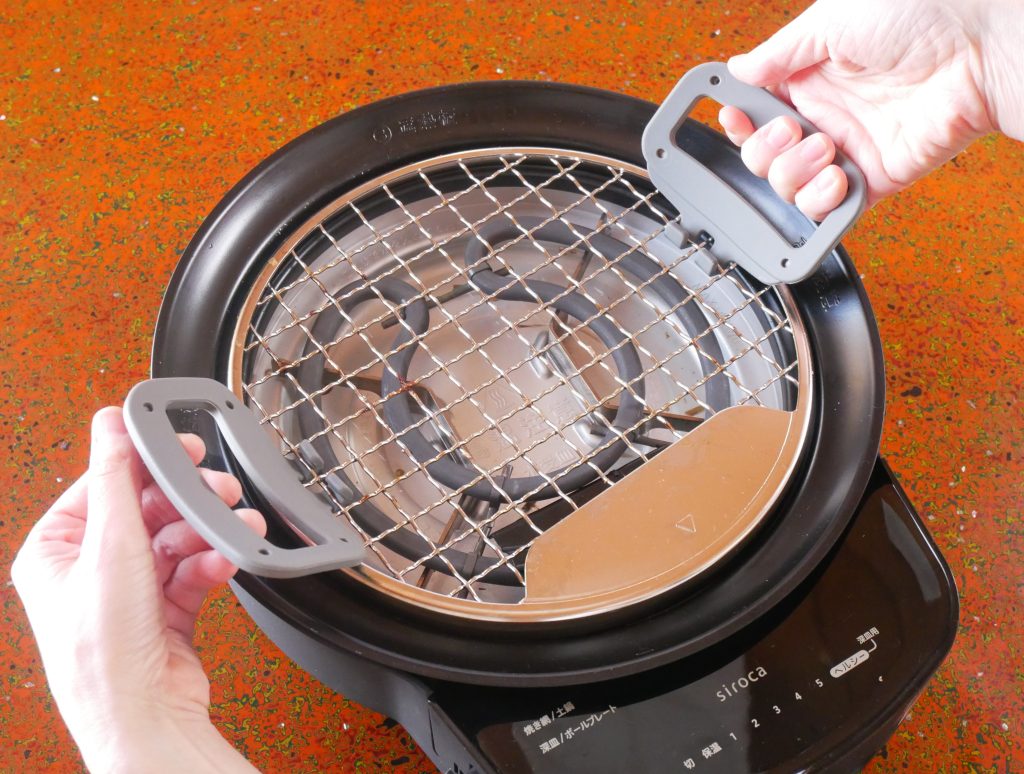取っ手で焼き網を持ち上げる様子