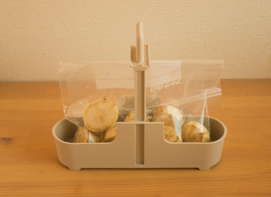 さつまいもが入った保存袋を、エッグ&ボイルクッカーのカゴにセットする様子