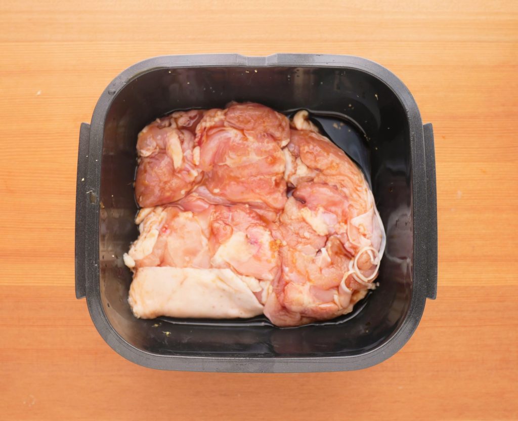 ラージカプセルに鶏もも肉を入れる様子