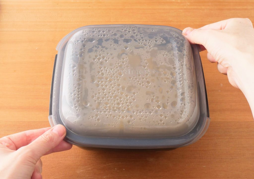 ラージカプセルのフタの右上と左下を持つ様子