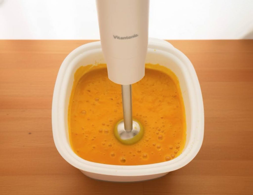 ハンドブレンダーで煮たかぼちゃと玉ねぎを攪拌する様子
