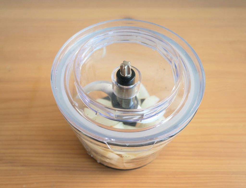 容器に玉ねぎを入れ、フタを取り付ける様子