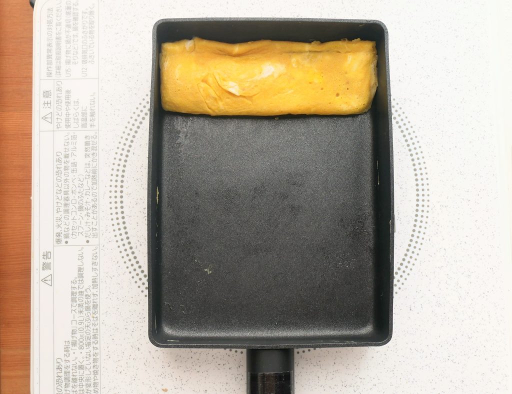 エッグパンの奥に玉子焼きを寄せる様子