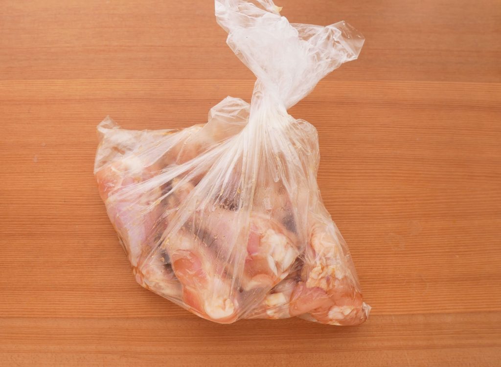 ポリ袋に入れて、鶏手羽元に下味を付ける様子