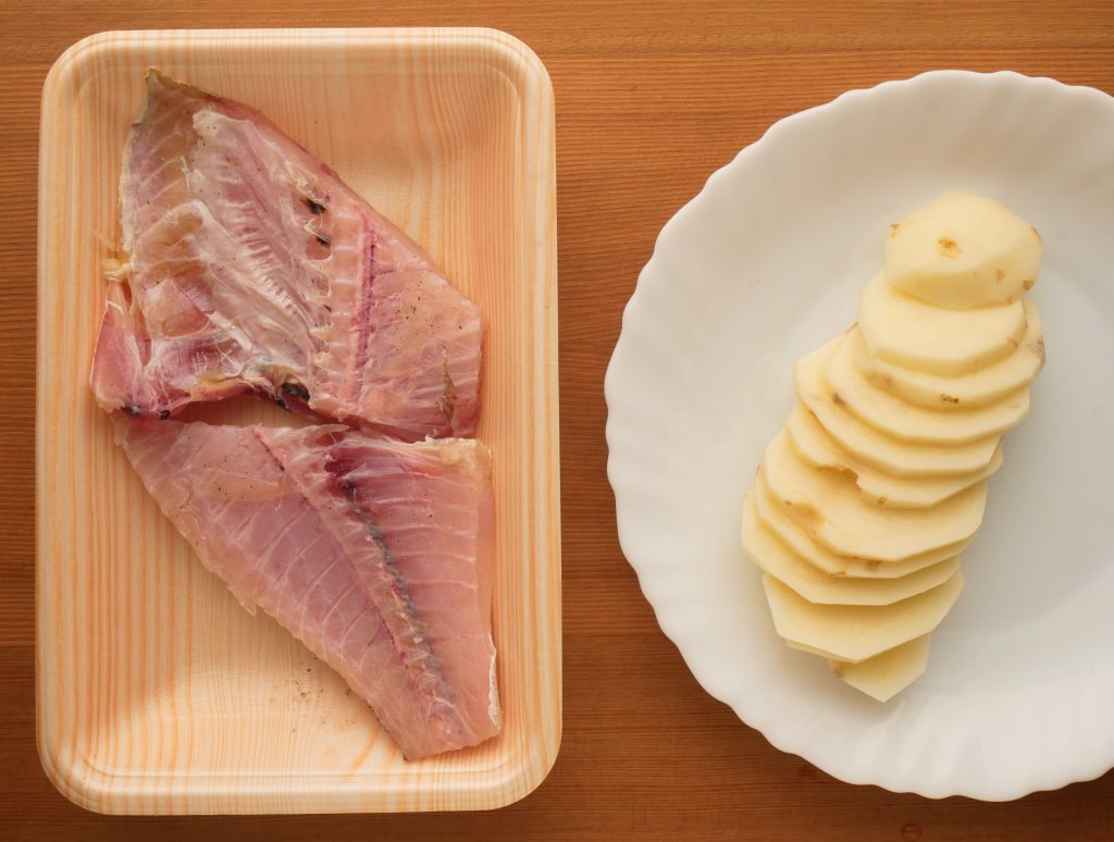 白身魚とじゃがいもを下ごしらえする様子