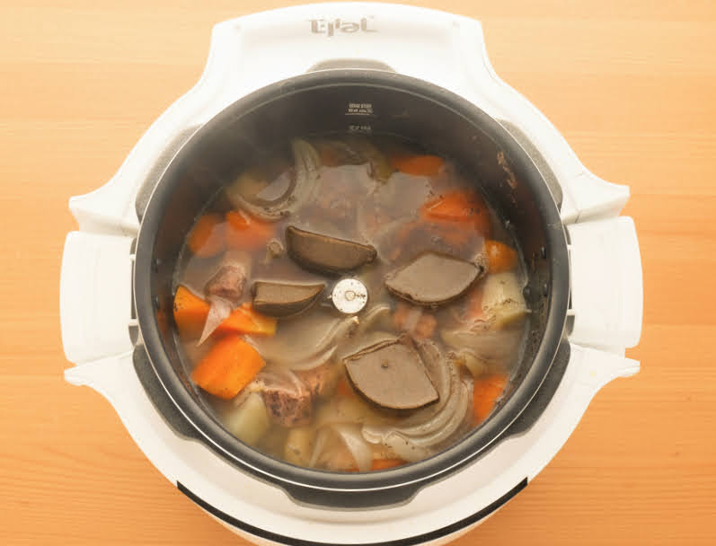 ラクラクッカープロ自動調理鍋にビーフシチューのルーを加える様子