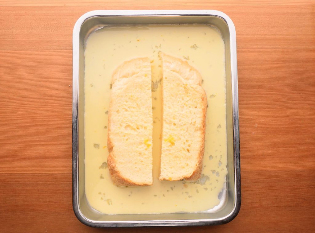 バットに入れた卵液に食パンを浸す様子