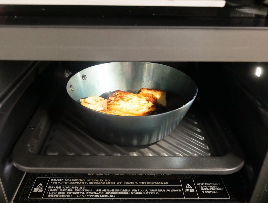 取っ手を取った鉄フライパンをオーブンに入れる様子