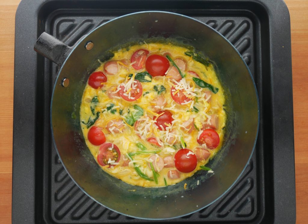 取っ手を外した鉄フライパンを天板にのせる様子