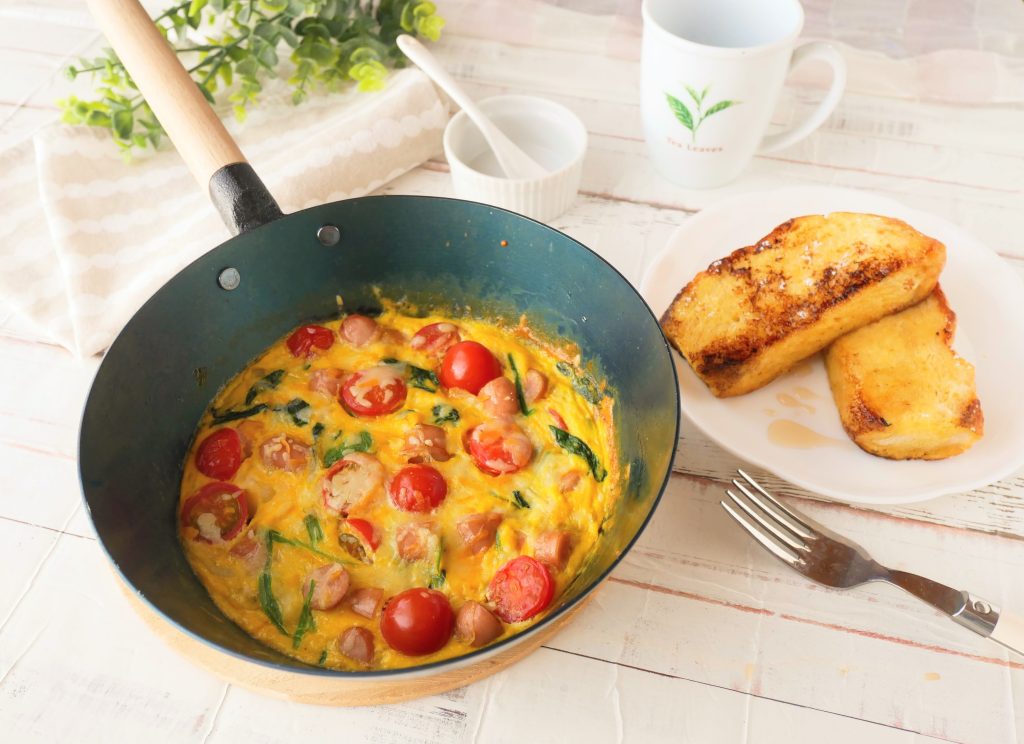 オーブンでも使える鉄フライパンに入ったオープンオムレツと、皿に盛られたフレンチトースト