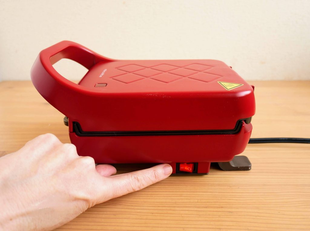 プレスサンドメーカープラッドの電源スイッチを入れる様子