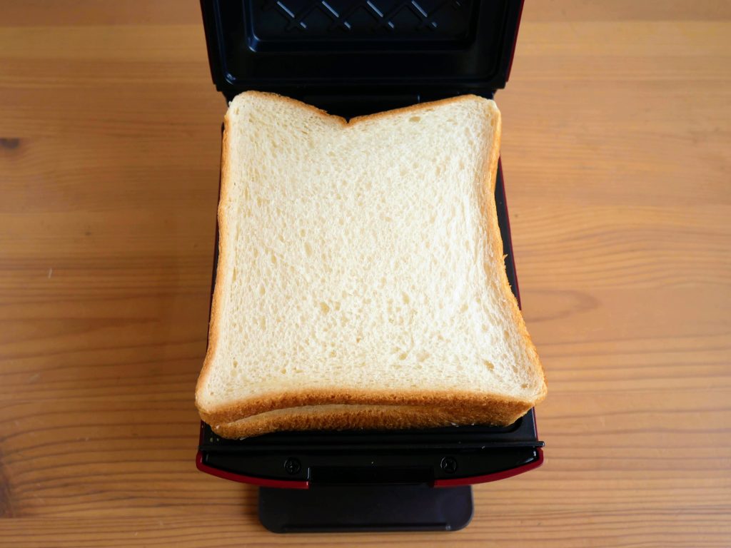 プレスサンドメーカープラッドに食パンをのせる様子