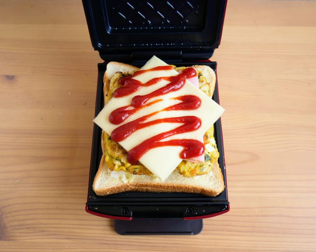 プレスサンドメーカープラッドにホットサンドの具材をのせる様子