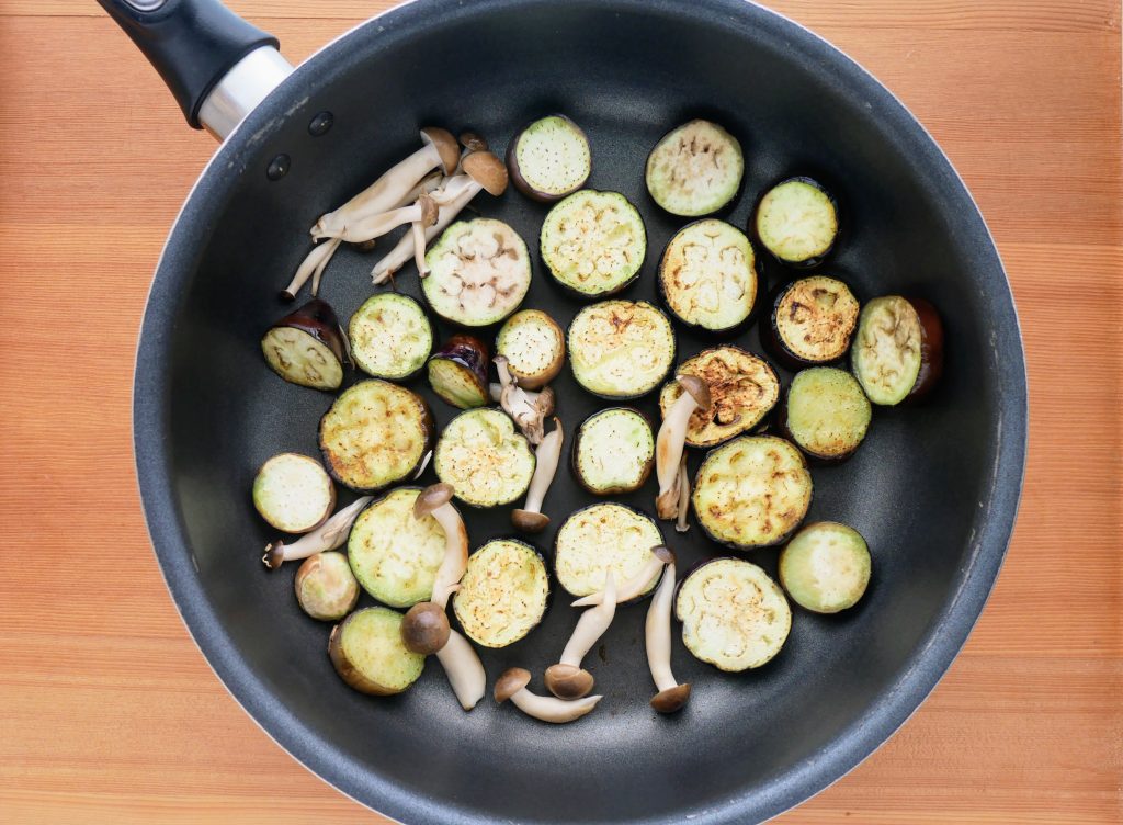 フライパンでなすとしめじを焼く様子
