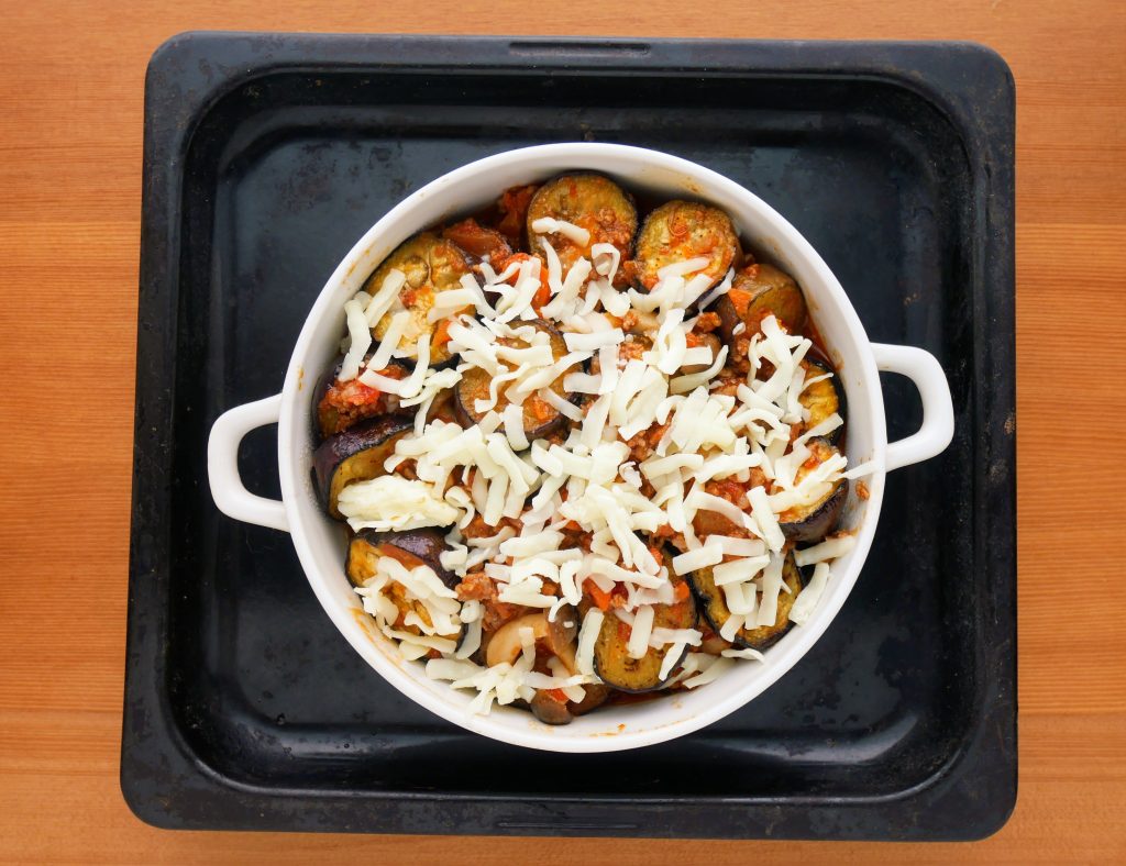 耐熱皿にのせてチーズをかけた、なすのミートソースグラタン