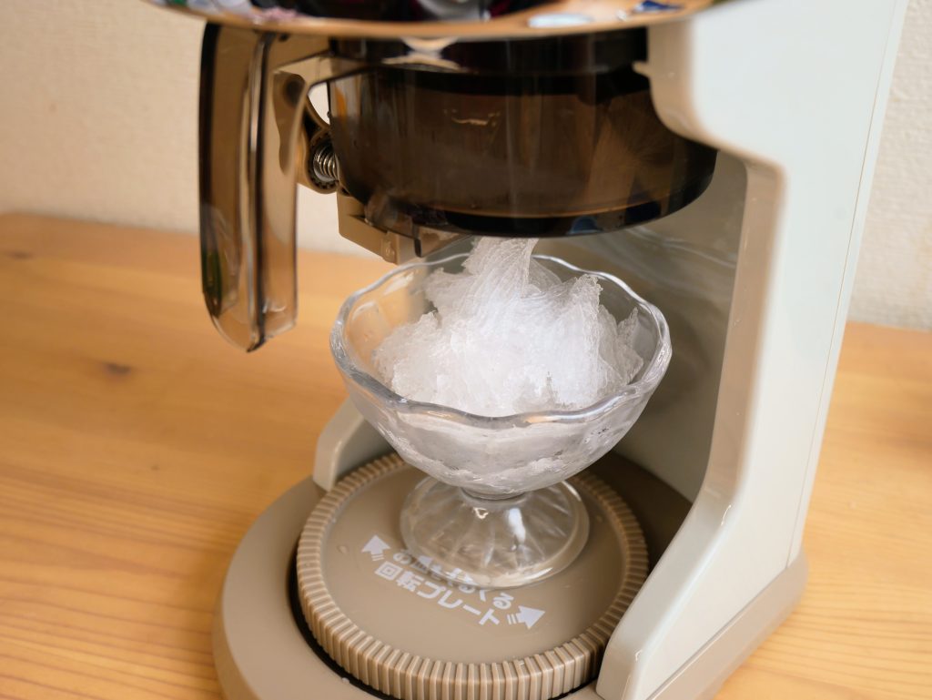 電動ふわふわかき氷器で氷を削る様子