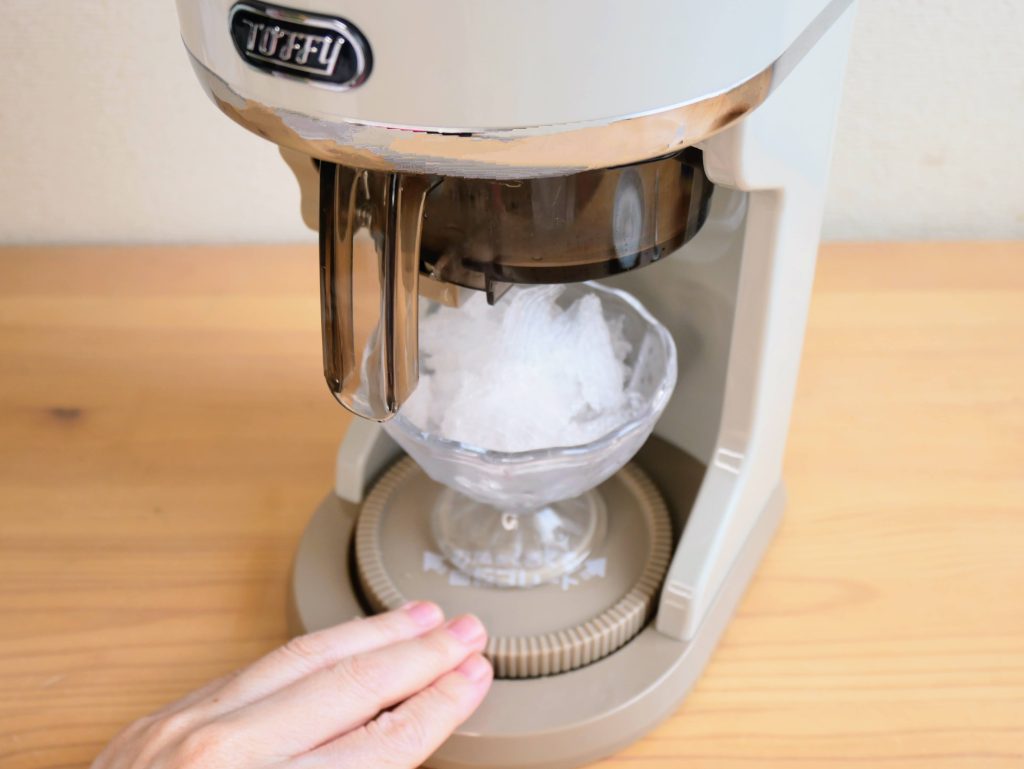 電動ふわふわかき氷器の回転プレートを手で動かす様子