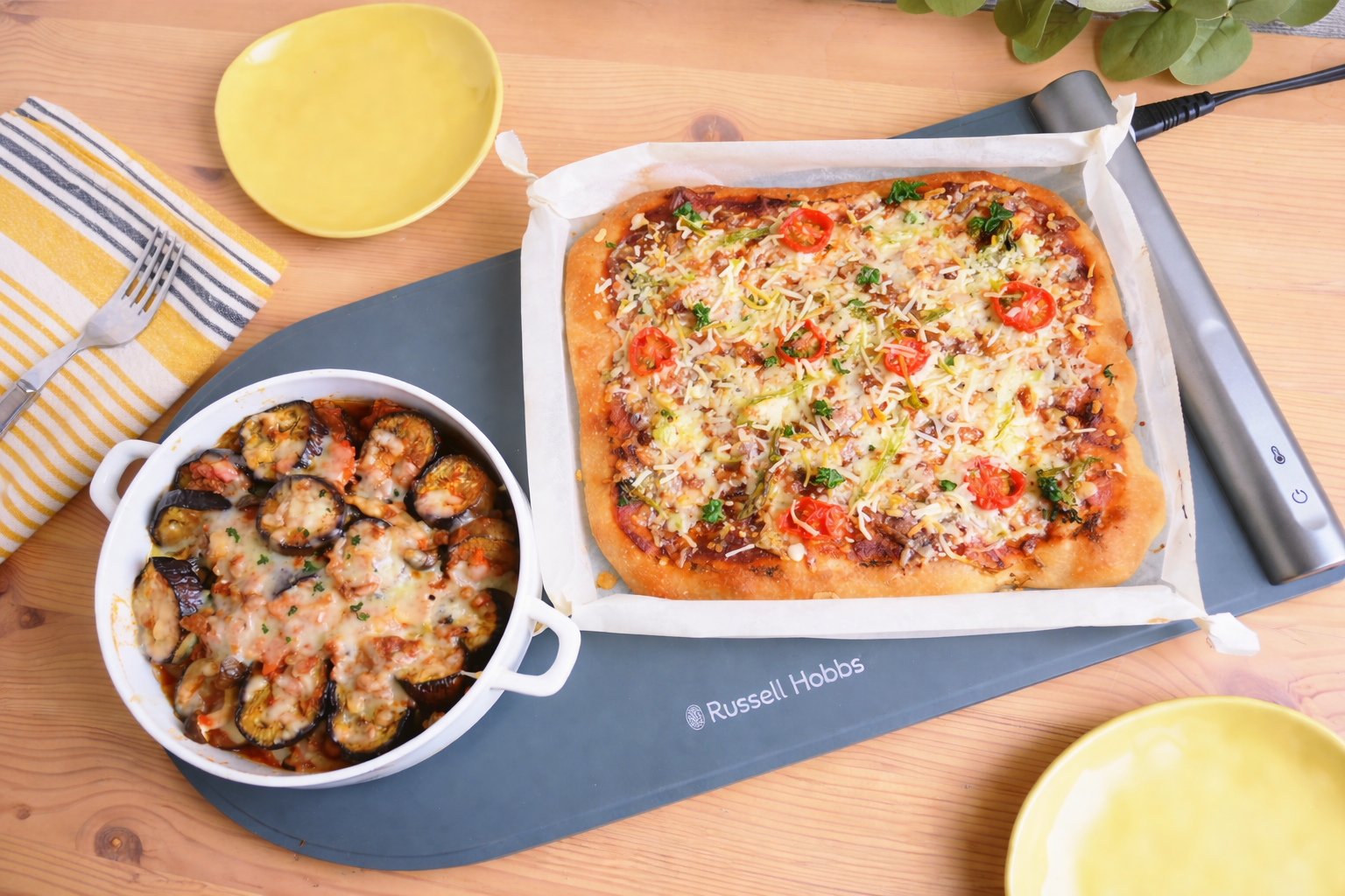 フードウォーマーパッドにのせた、ピザとなすのミートソースグラタン