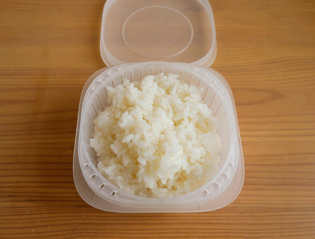 蒸気であたためる冷凍ごはん容器にごはんを入れるところ