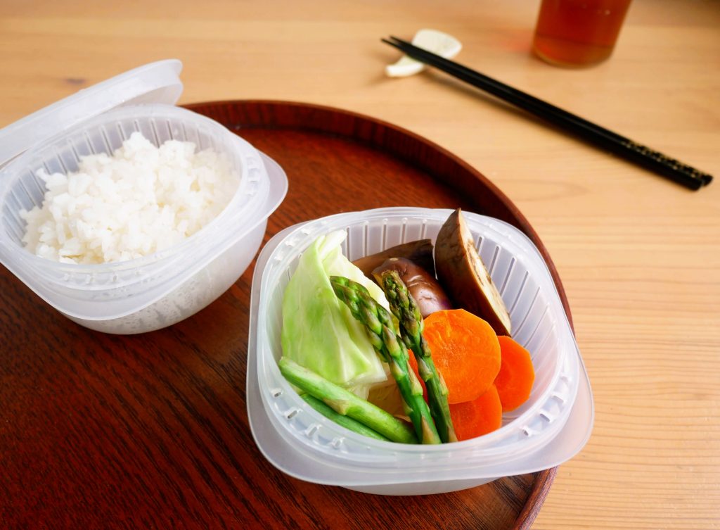 蒸気であたためる冷凍ごはん容器に入った温野菜とごはん