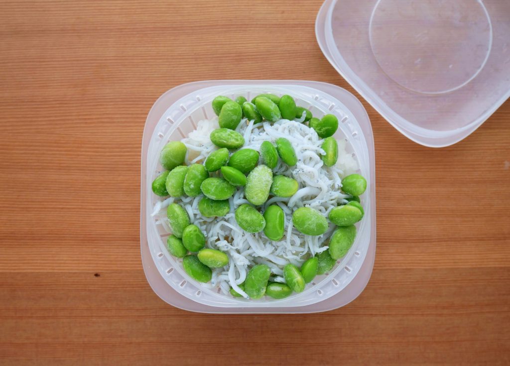 蒸気であたためる冷凍ごはん容器に入った冷凍ごはんに、しらすと枝豆をのせる様子