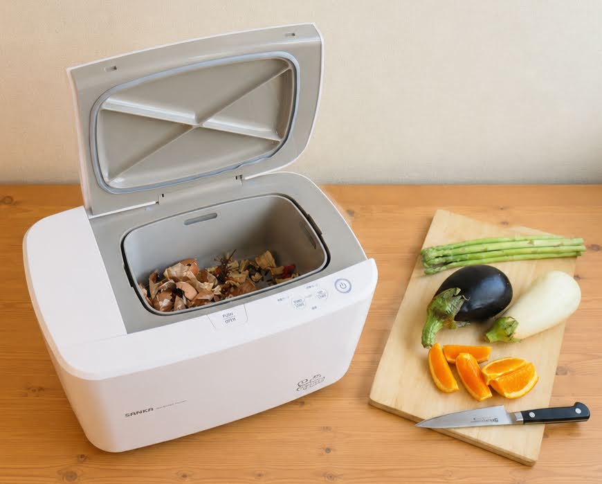 ふたを開けた生ごみ処理機とまな板にのった野菜とフルーツ