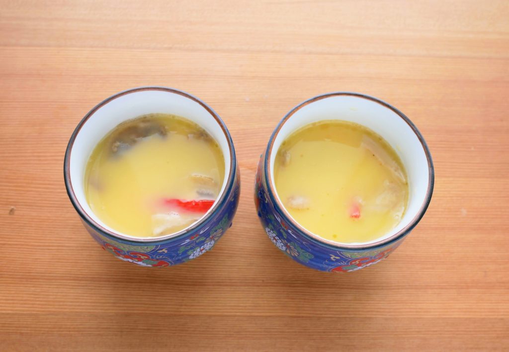 耐熱容器に卵液と具材を入れる様子