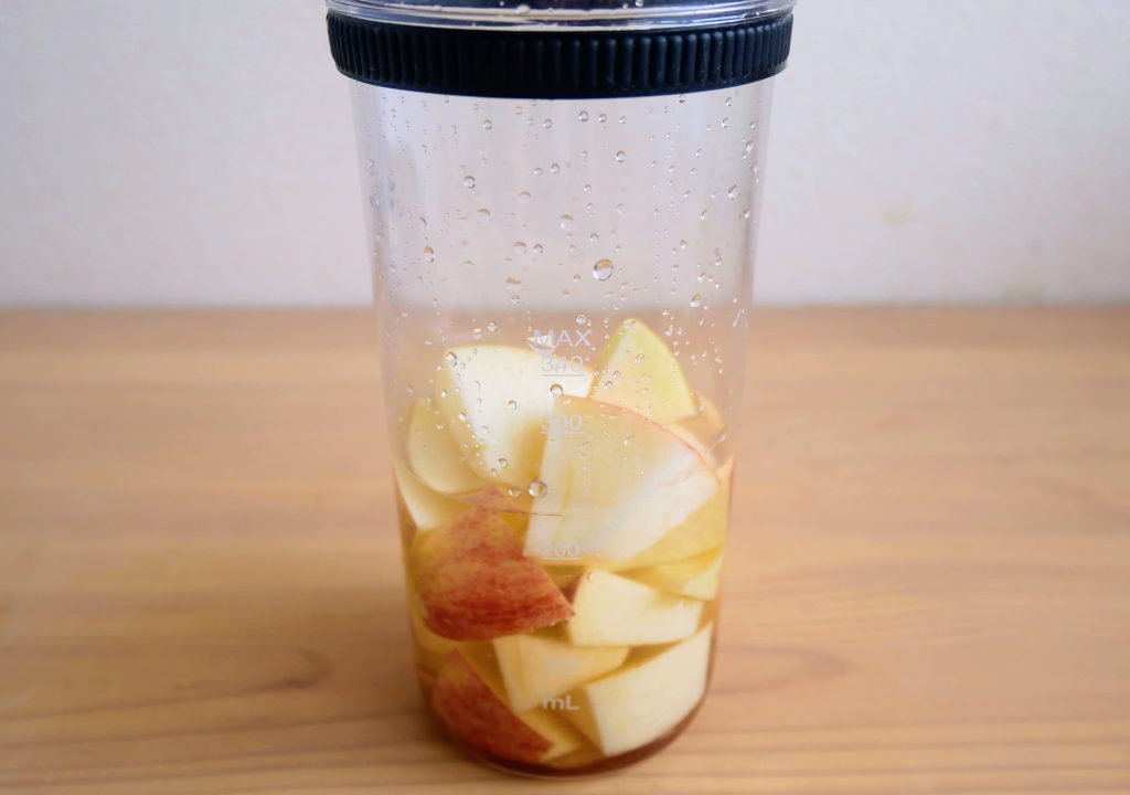 ブレンダーカップにりんごスムージーの材料を入れる様子