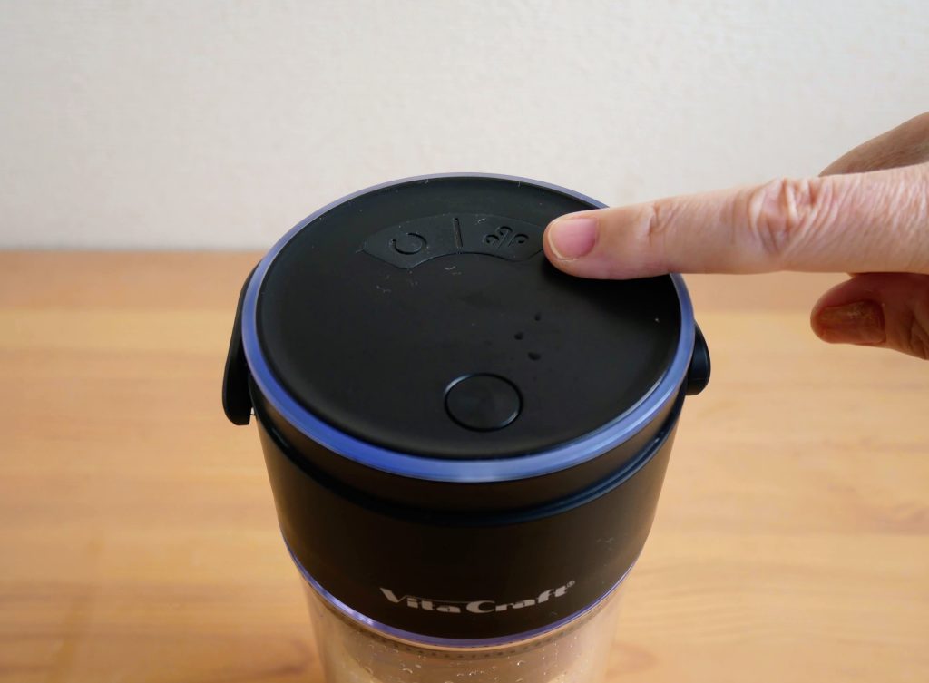 ブレンダーカップの真空ボタンを押す様子
