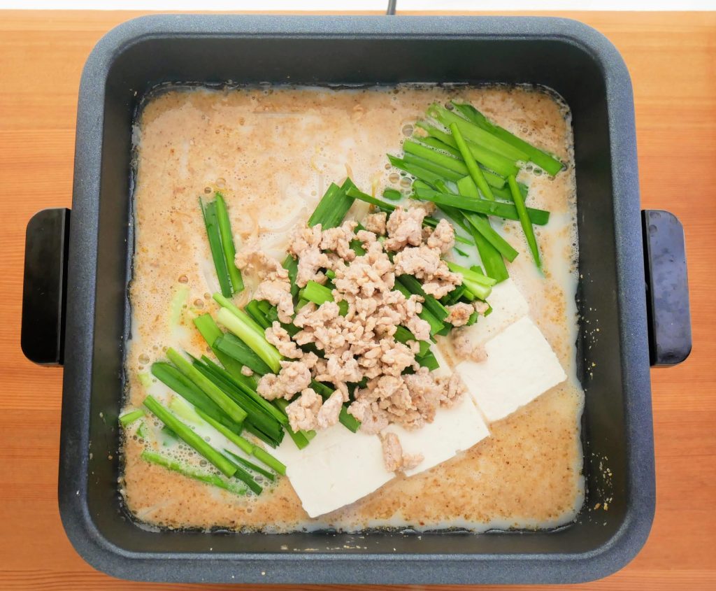 にらと豚ひき肉をのせる様子