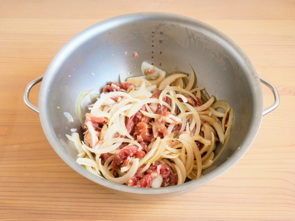 すっきり暮らす 火にかけられるボウル で豚肉と玉ねぎを調味液につける様子