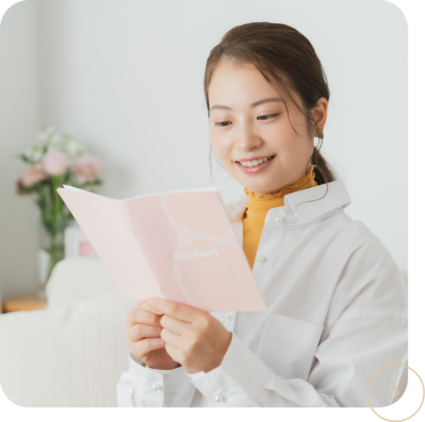 笑顔で資料を見る女性の写真